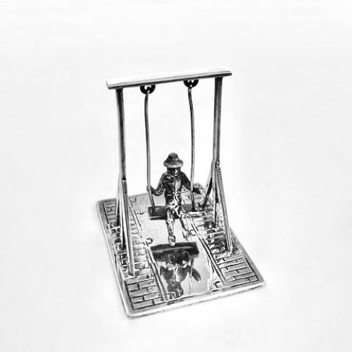 Miniature silver model of man on a swing.