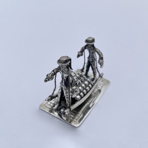 Miniature model of two men carrying Gouda cheese.