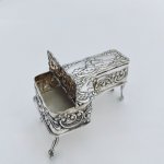 Miniature embossed silver baby grand style piano box.